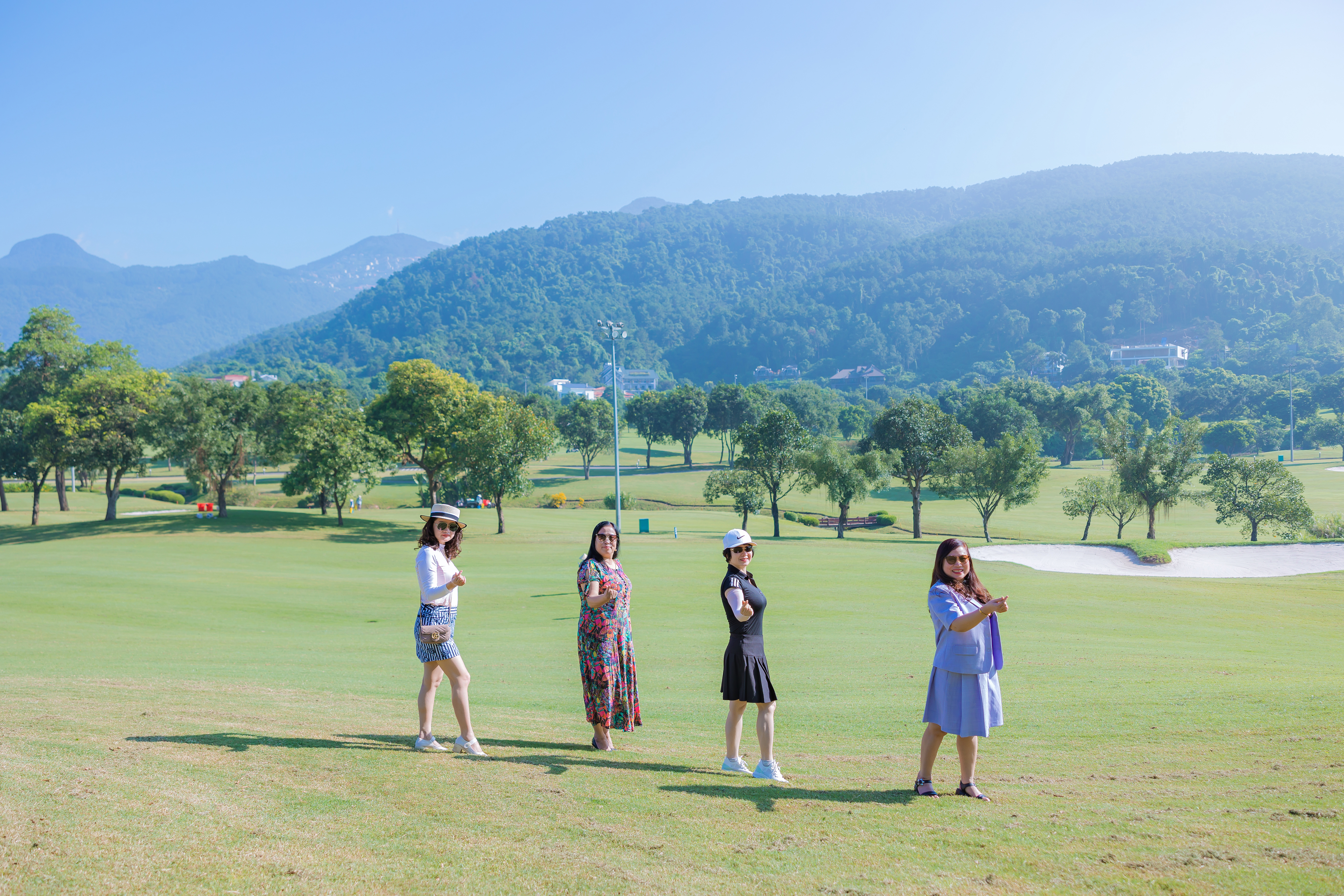 Nhóm bạn check-in giữa thảm cỏ xanh Sân Golf Tam Đảo, phông nền núi Tam Đảo